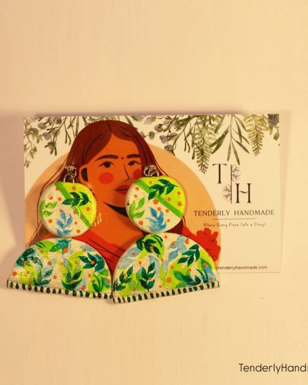 Green floral hand-painted earrings displayed on a Tenderly Handmade card featuring an illustrated woman and botanical motifs.