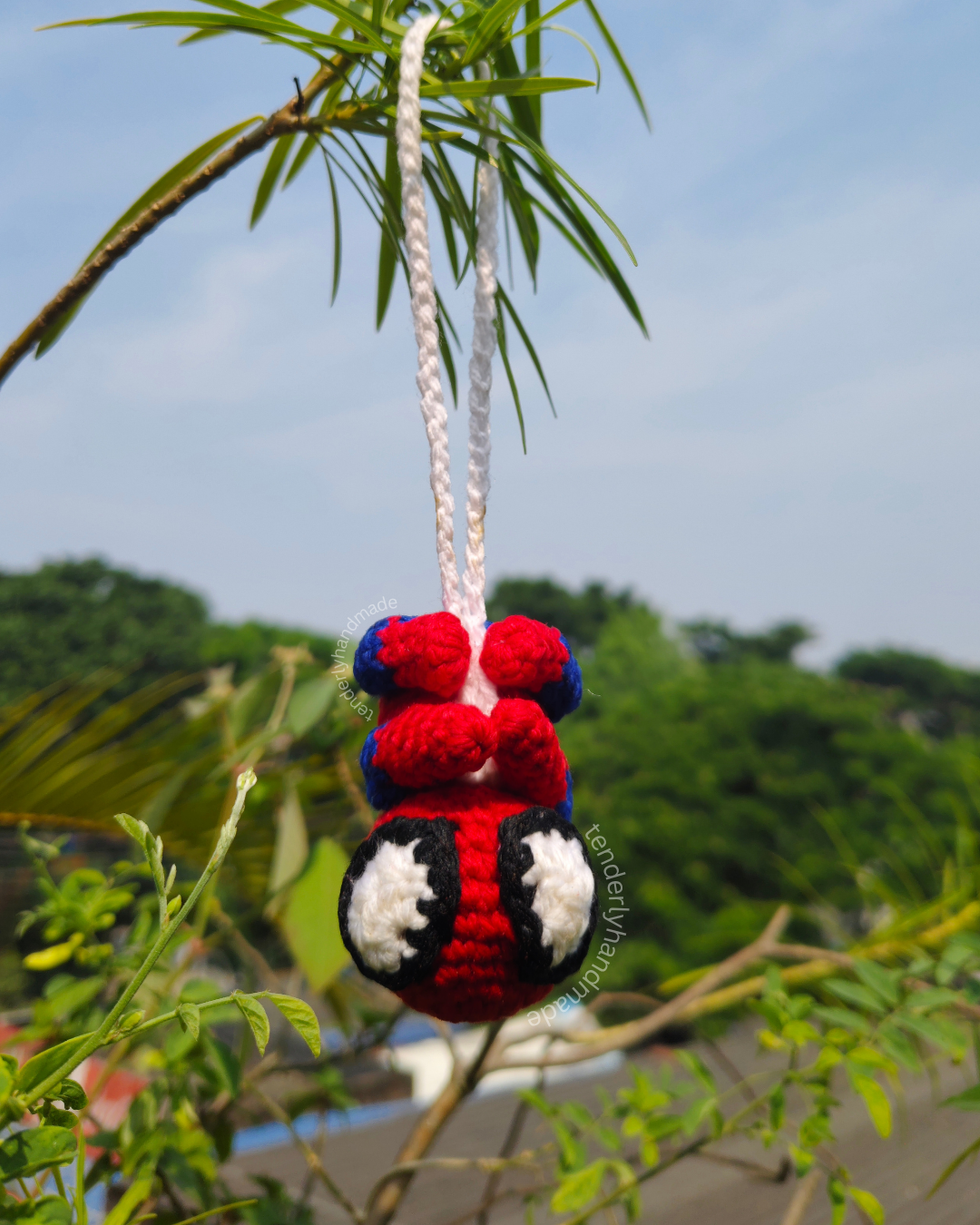 Handmade crochet spiderman car hanging ornament suspended upside down outdoors by Tenderly Handmade